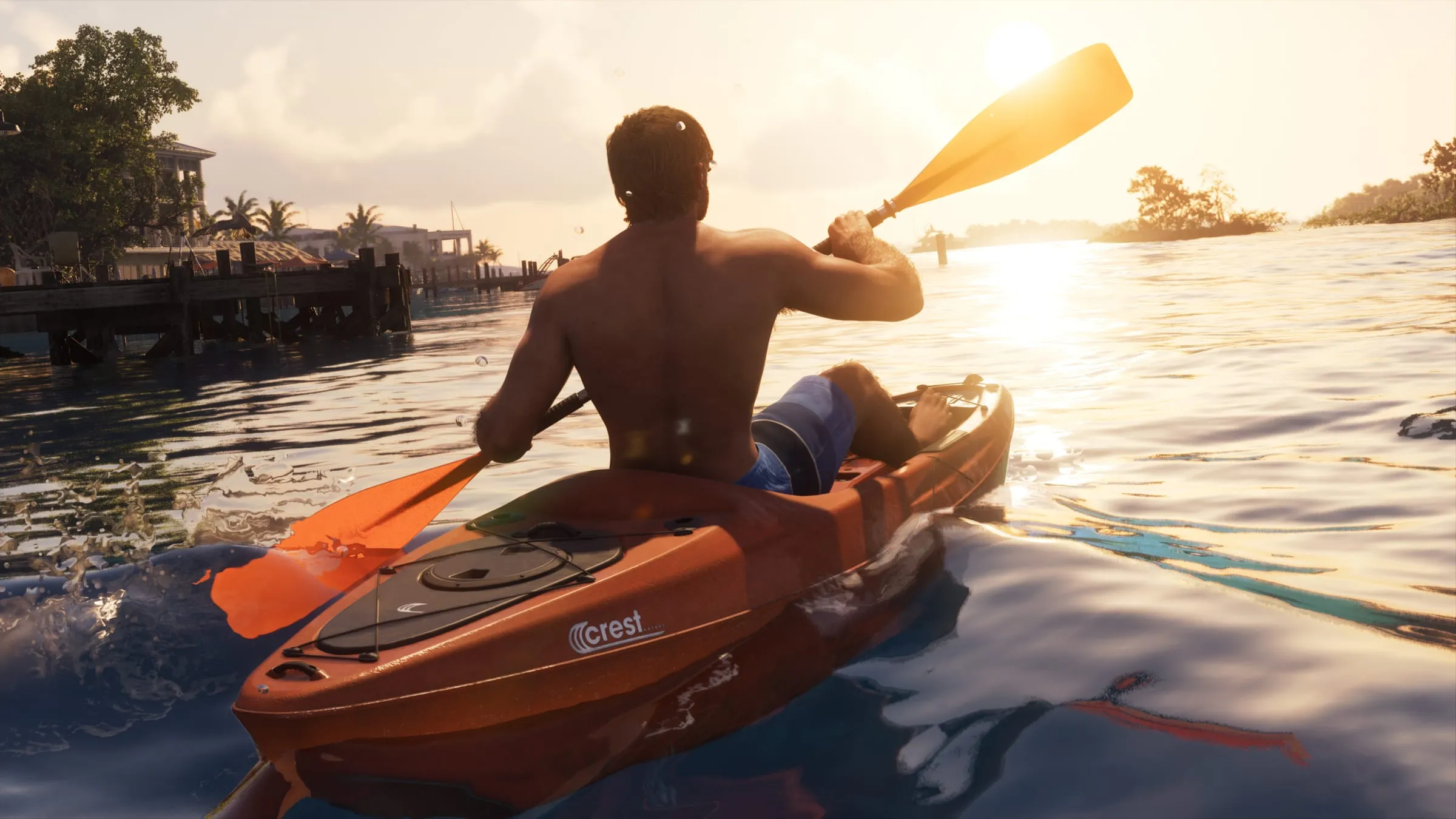 Jason a torso nudo pagaia su un Crest Kayak arancione con il marchio Crest ben leggibile, al tramonto vicino a un pontile