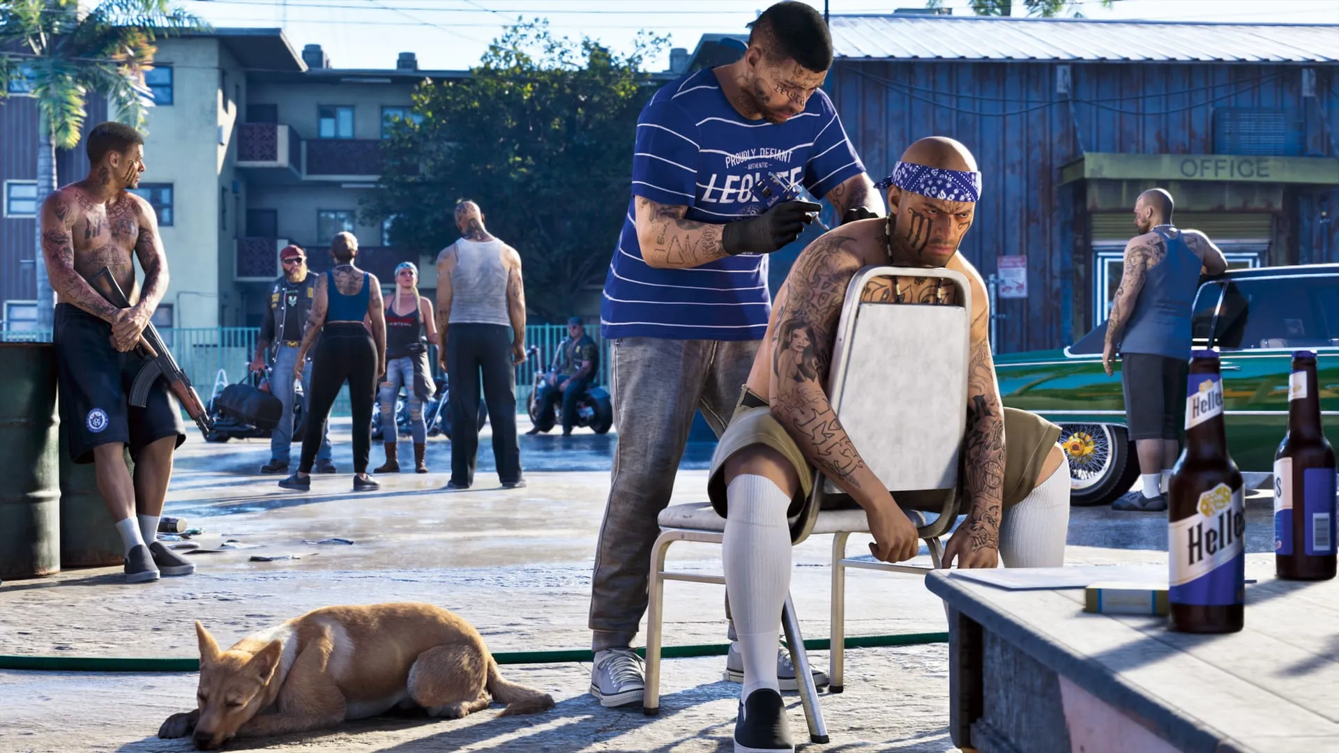 In un cortile un uomo si fa tatuare la spalla su una sedia pieghevole, mentre un altro con un fucile fa la guardia e un cane dorme sull'asfalto