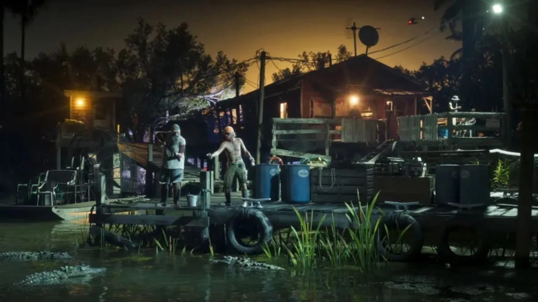 Screenshot ufficiale di GTA VI: di notte due uomini su un pontile di legno davanti a una casa sulla palude, con un airboat ormeggiato e diversi alligatori nell'acqua sotto di loro