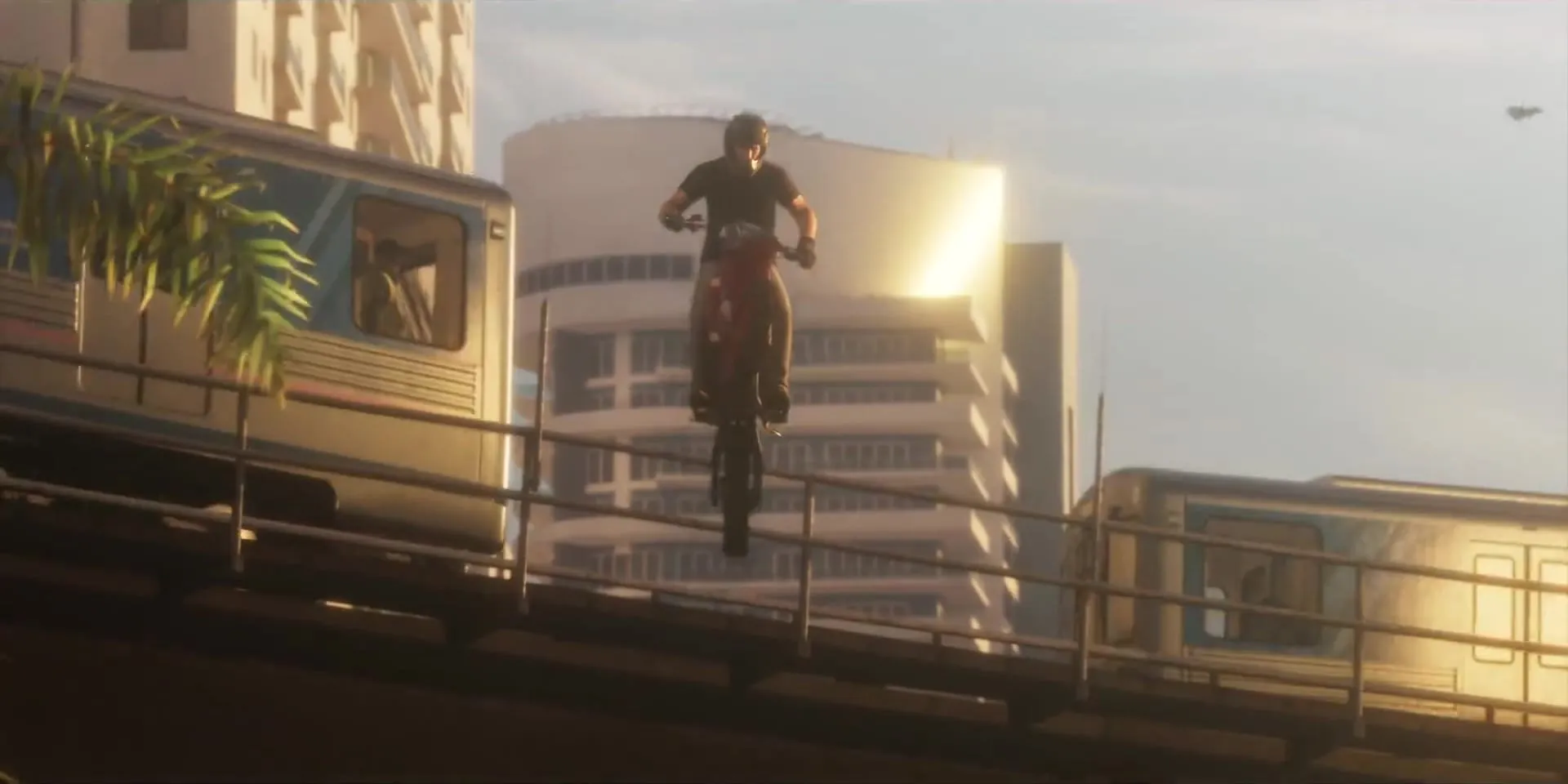 A rider jumps a dirt bike over the elevated line, between two train cars