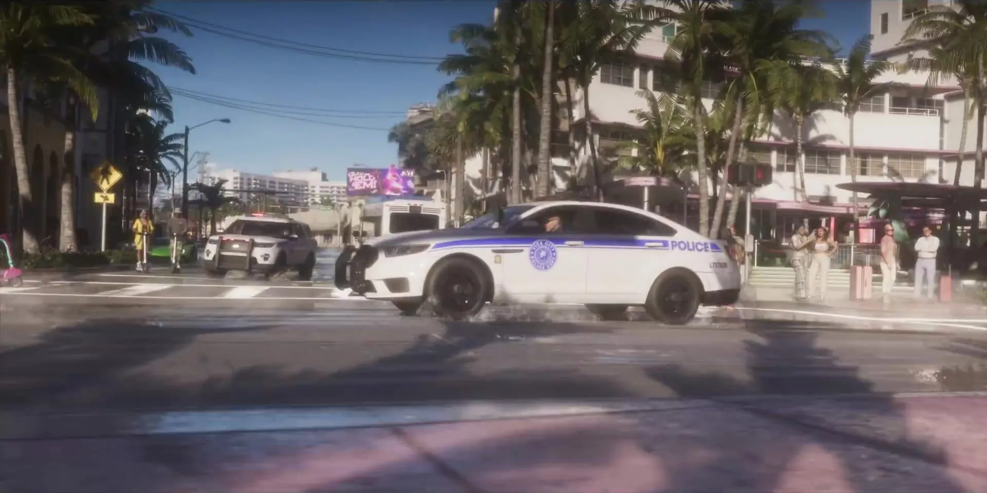 Police cars sliding along a street with art deco hotels and palm trees