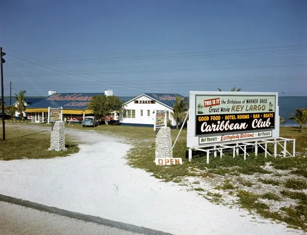 Il Caribbean Club di Key Largo intorno al 1950: edifici bassi in riva al mare e un grande cartello che lo presenta come il luogo di nascita del film Key Largo della Warner Bros