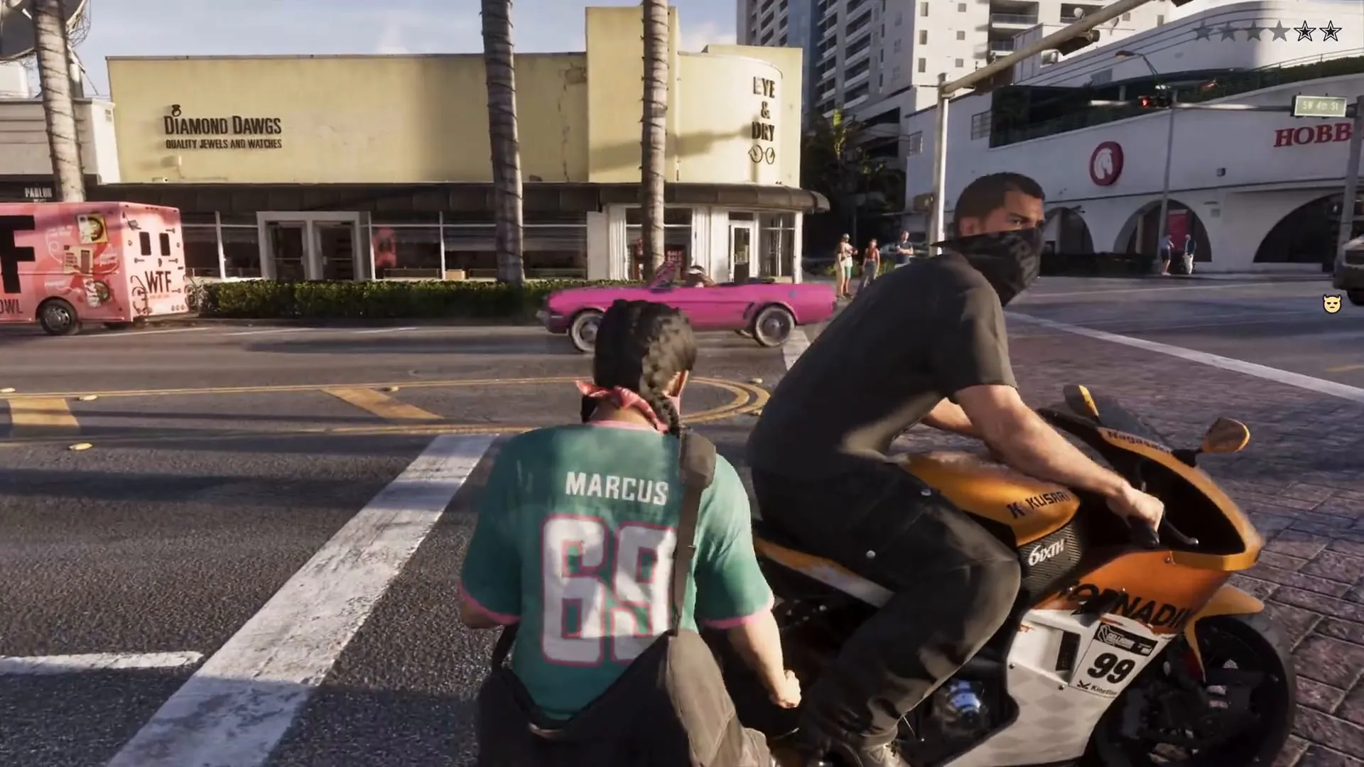 The corner with the Diamond Dawgs jewellery store, a pink food truck reading WTF and a fuchsia convertible, as Jason rides past with Lucia